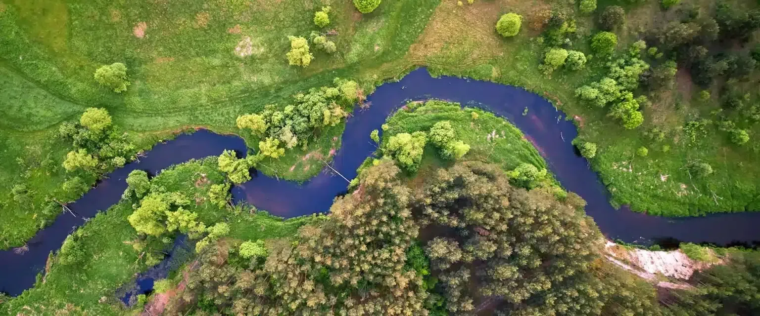 Aerial view of a looping river through a green landscape